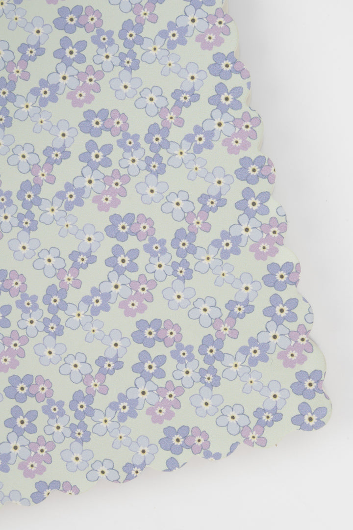 detail of a scalloped-edge notebook with an all-over small flower pattern in pastel colours