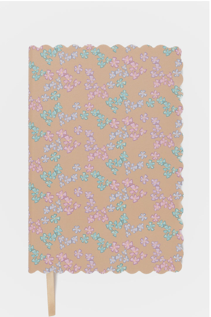 front view of a scalloped-edge notebook with an all-over small flower pattern in pastel colours