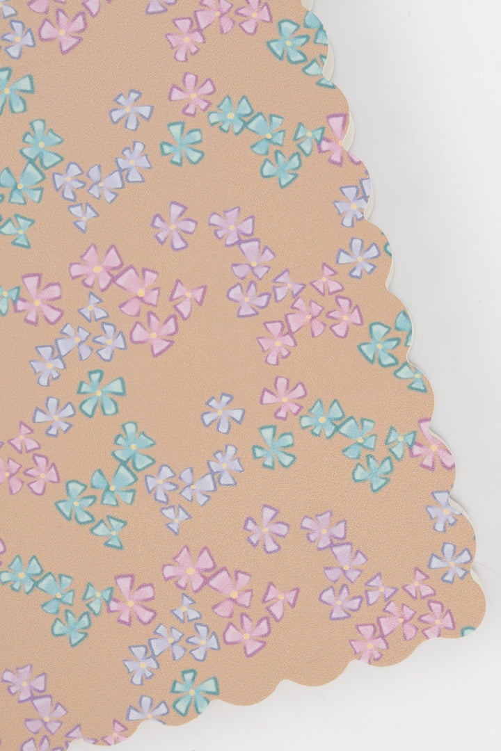 detail of a scalloped-edge notebook with an all-over small flower pattern in pastel colours