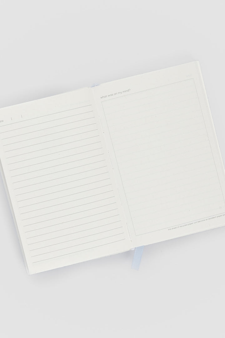 open diary with lined pages on the left and blank doodle page on the right
