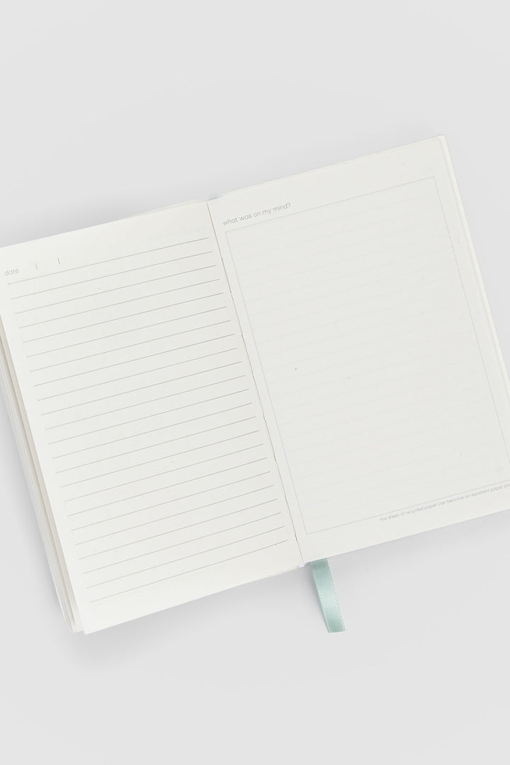 open diary with lined pages on the left and blank doodle page on the right
