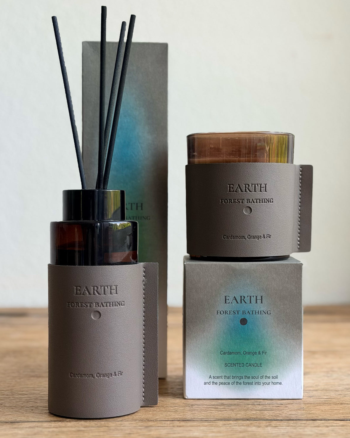 Natural looking reed diffuser and scented candle and their packaging on a natural background