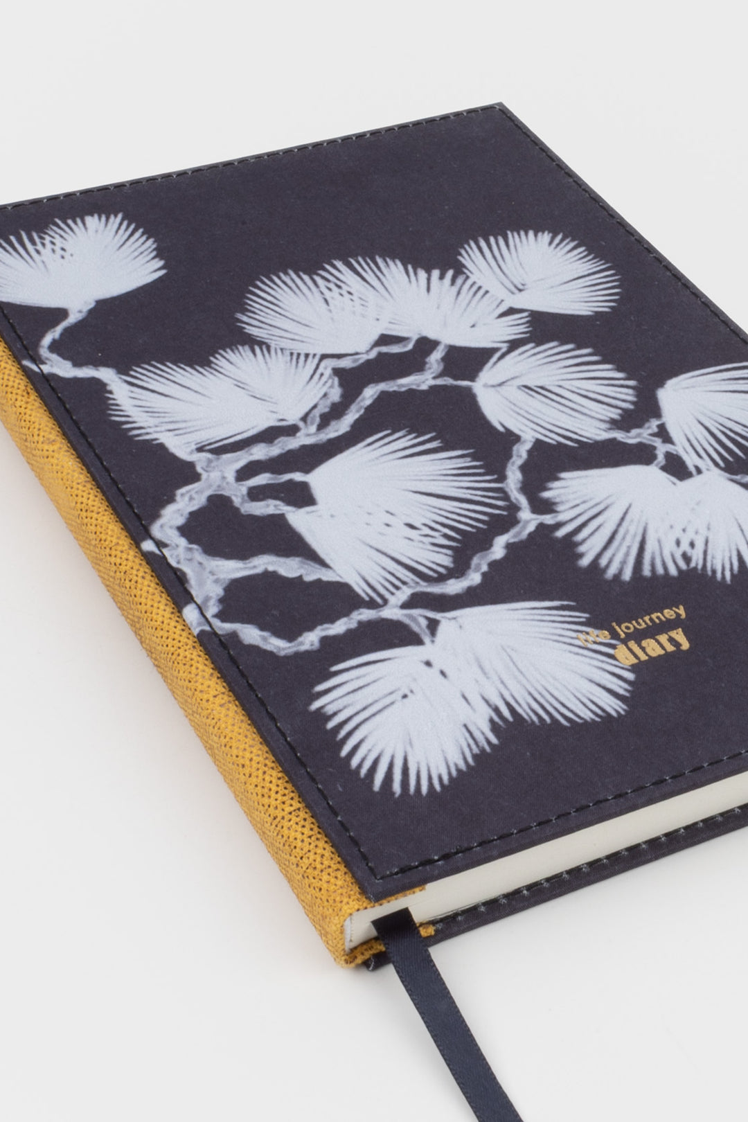 A5 diary angled view showing fabric cover botanical print and gold speckled spine