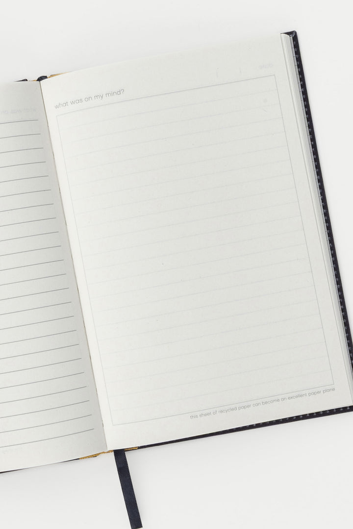 Open A5 diary showing lined and blank recycled paper pages with ribbon bookmark