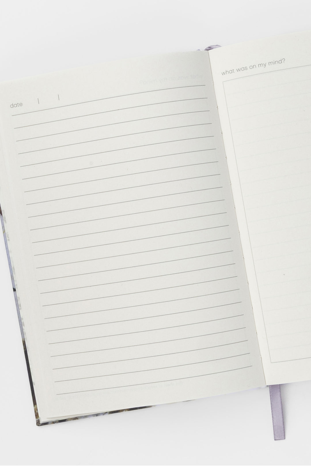 Open A5 diary showing lined pages with ribbon bookmark visible
