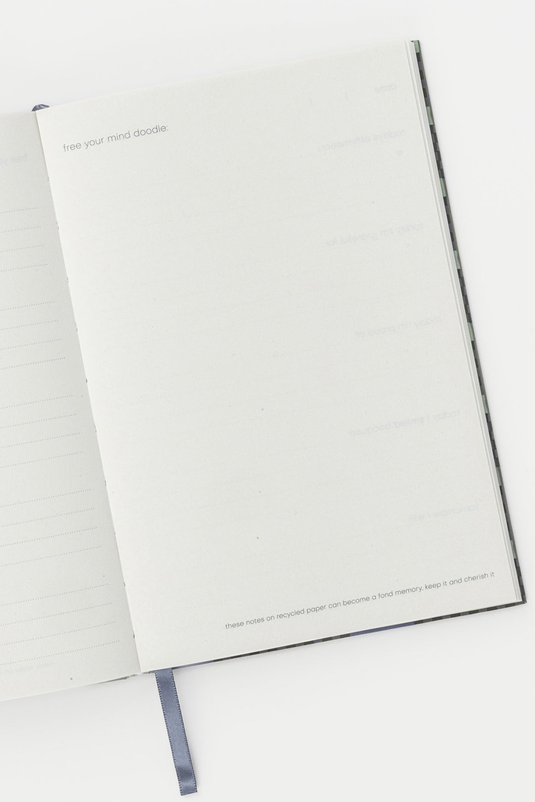Open A5 journal showing lined and blank recycled paper pages with ribbon bookmark visible