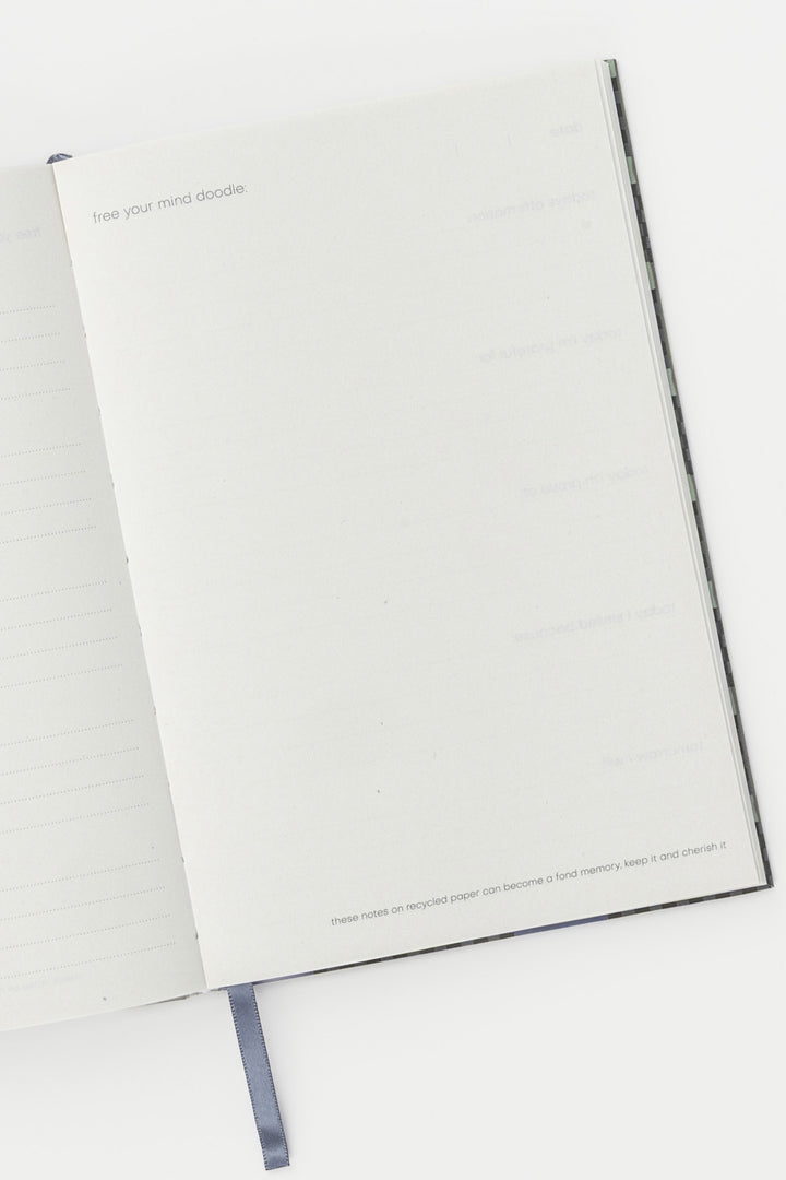 Open A5 journal showing lined and blank recycled paper pages with ribbon bookmark visible