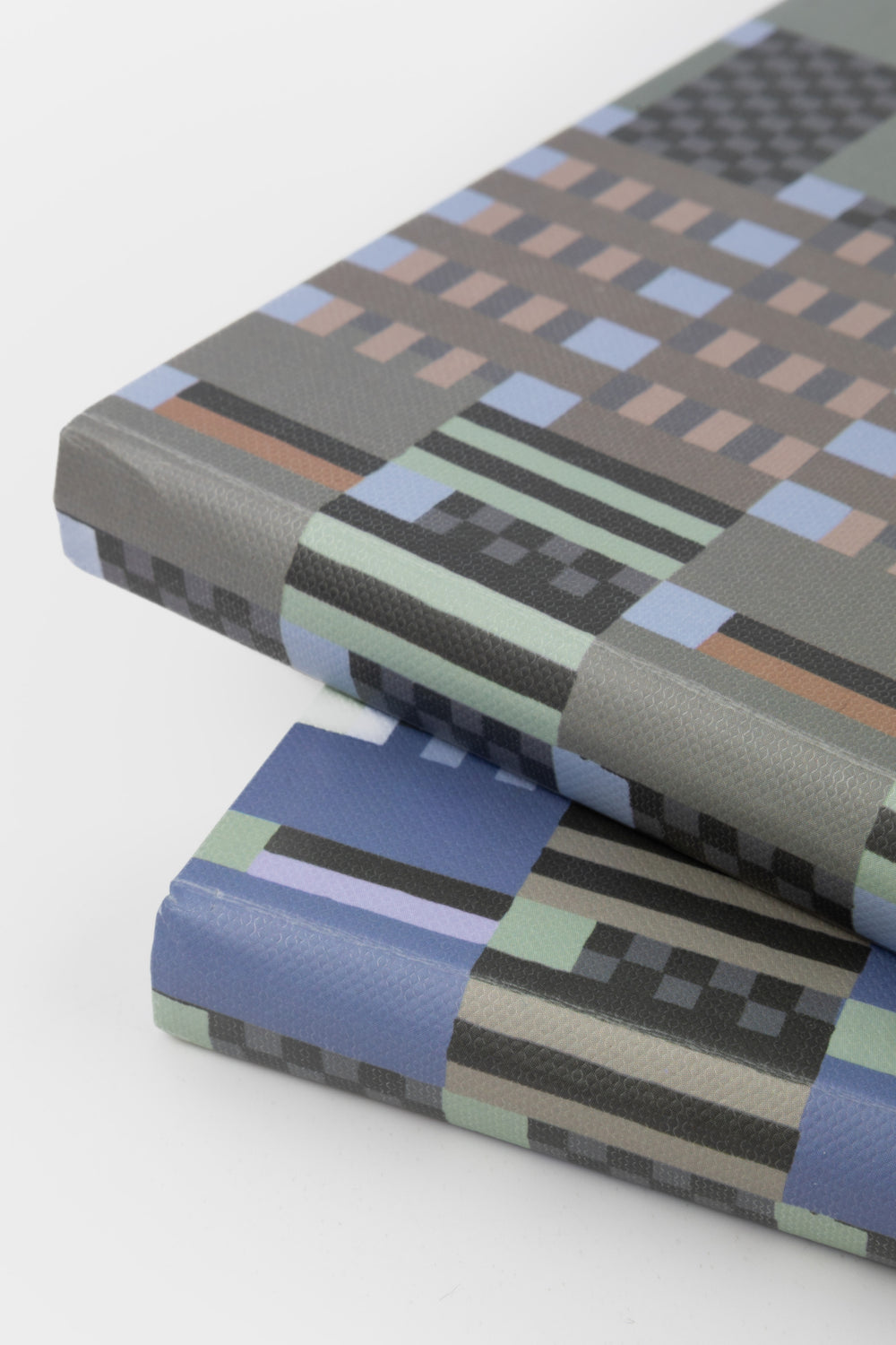 A5 journal with green and grey geometric paper cover stacked showing spine and cover texture