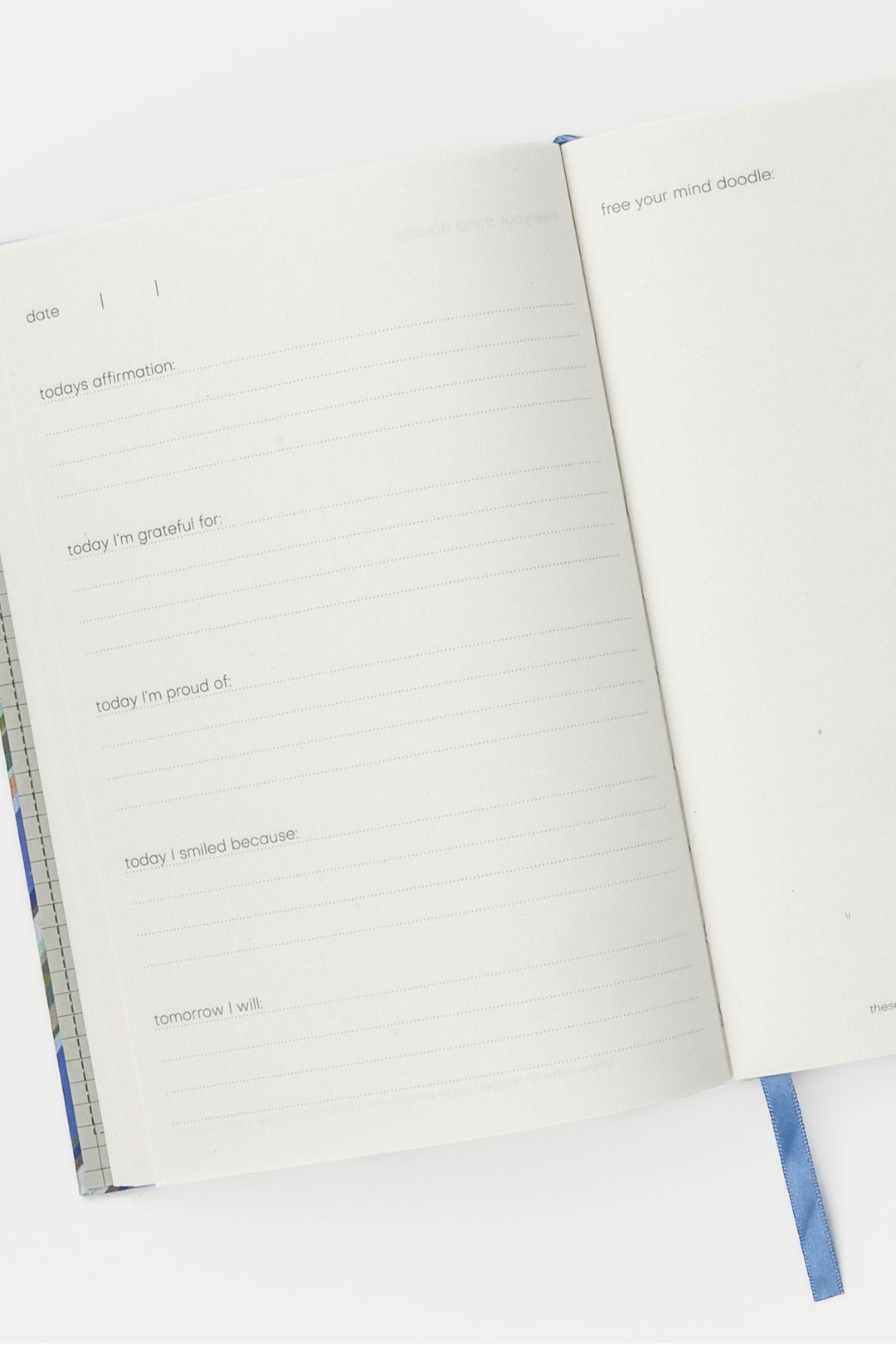 inside pages of a5 journal with guided prompts and blue ribbon marker
