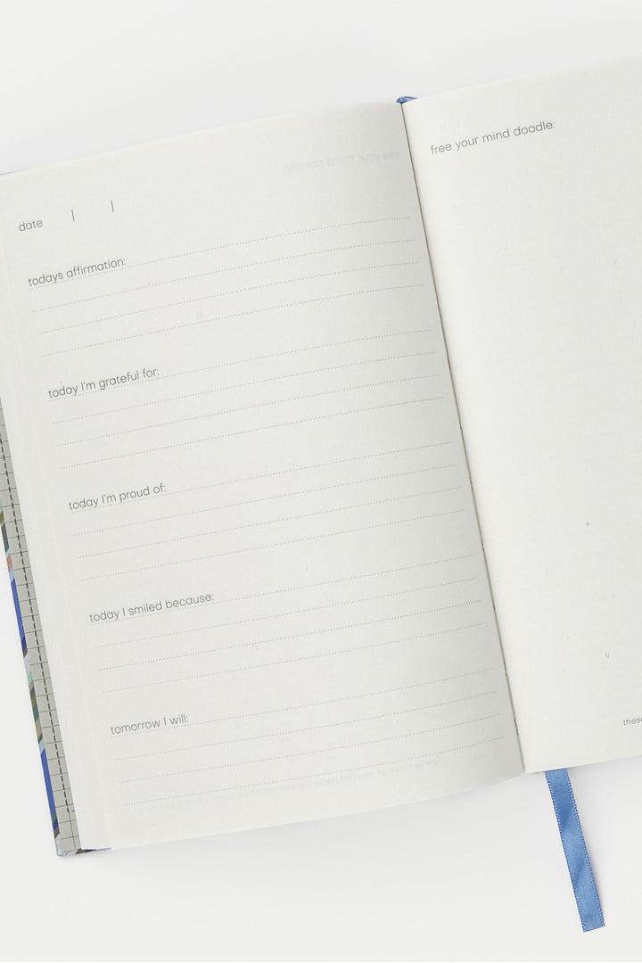inside pages of a5 journal with guided prompts and blue ribbon marker
