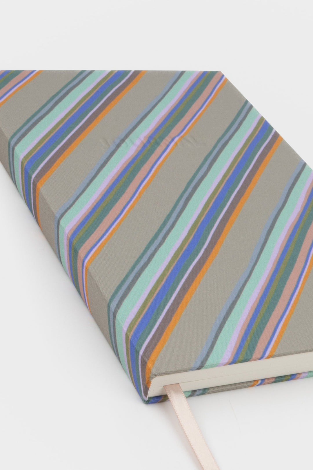 corner detail of a5 journal showing grey diagonal stripe cover and ribbon marker
