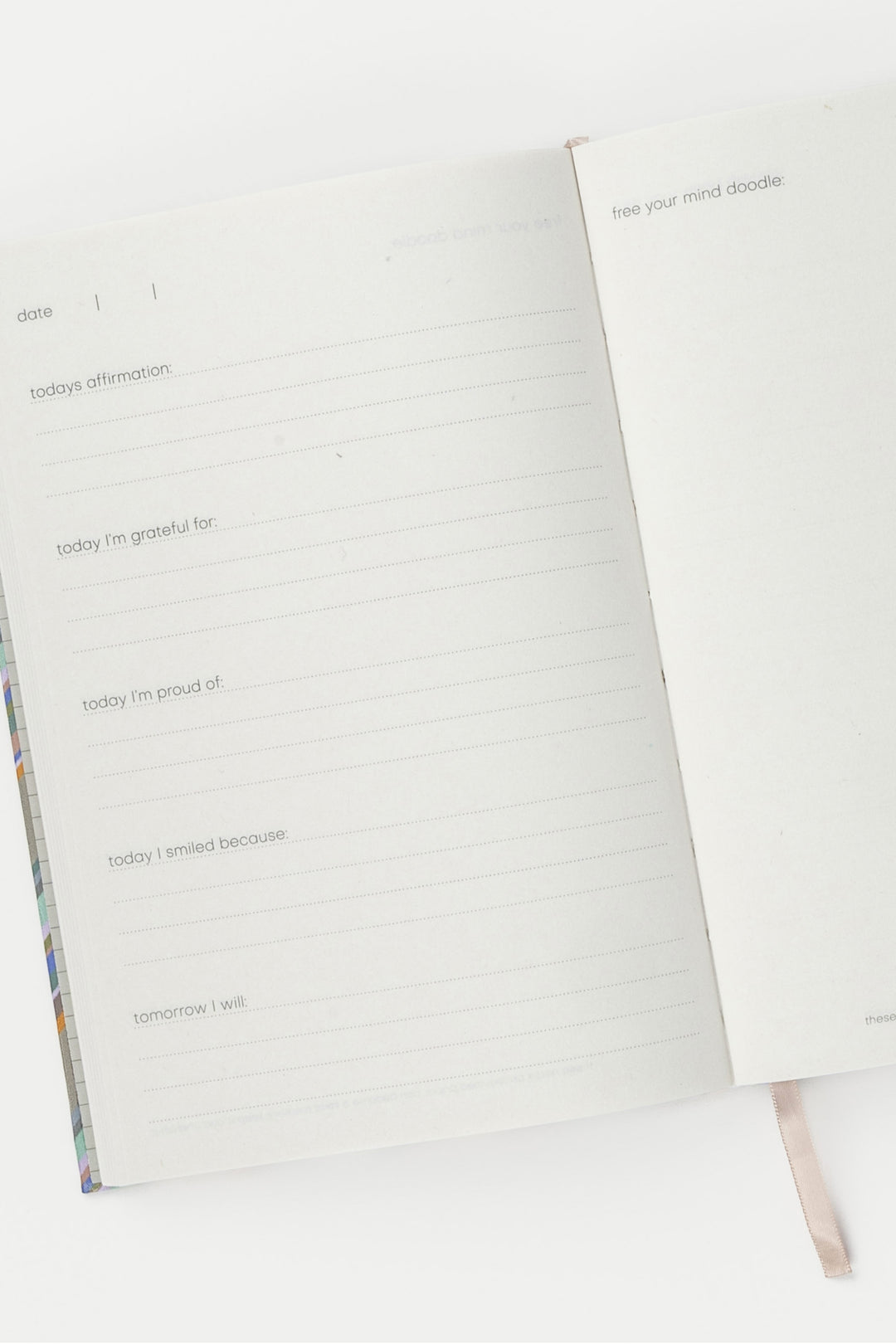 inside pages of a5 journal with guided prompts and blue ribbon marker