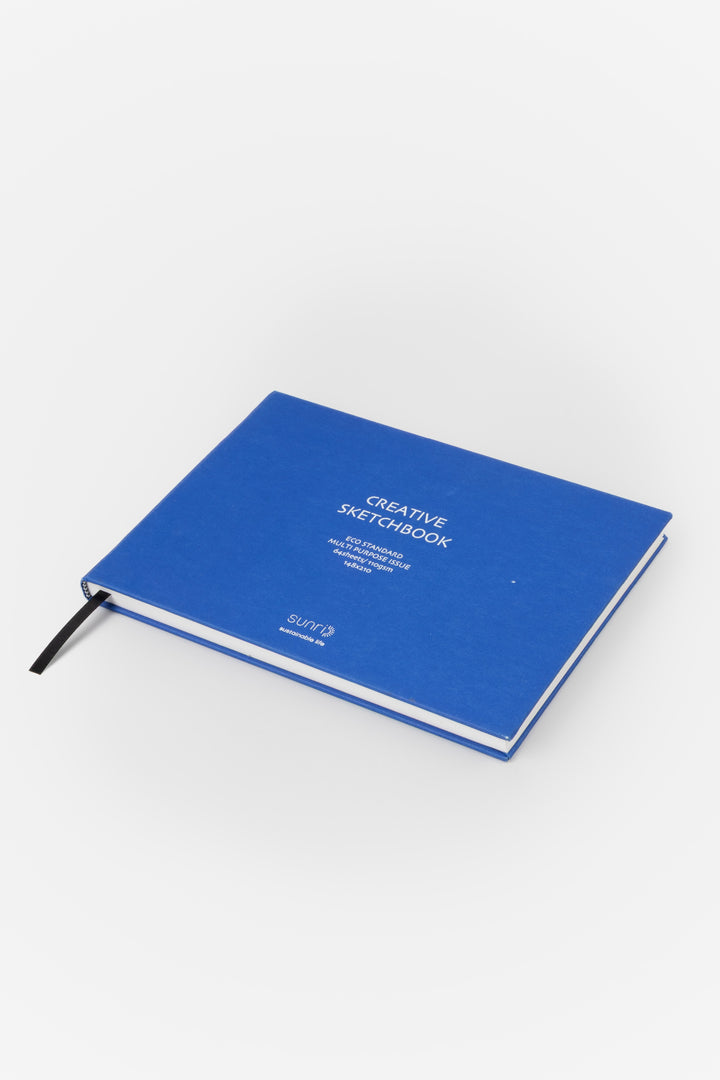 blue landscape sketchbook viewed from a low angle showing the black page marker