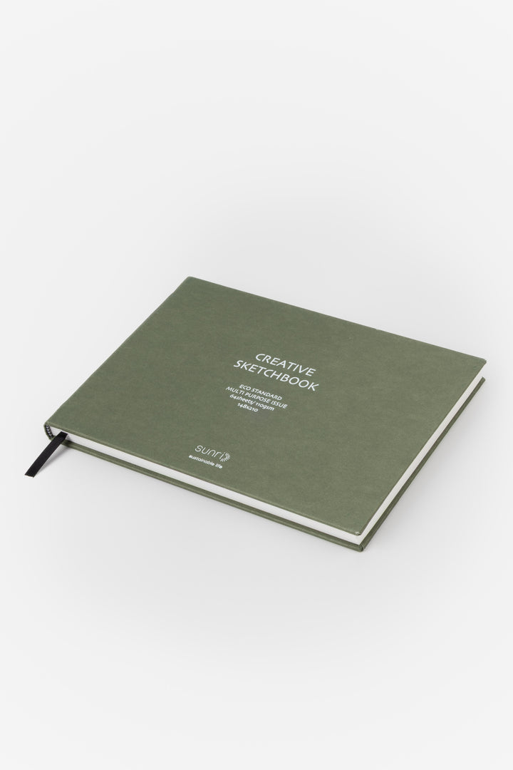 green landscape sketchbook viewed from a low angle showing the black page marker