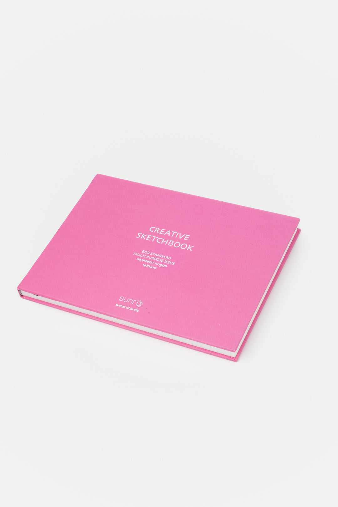 pink landscape sketchbook viewed from a low angle showing the black page marker