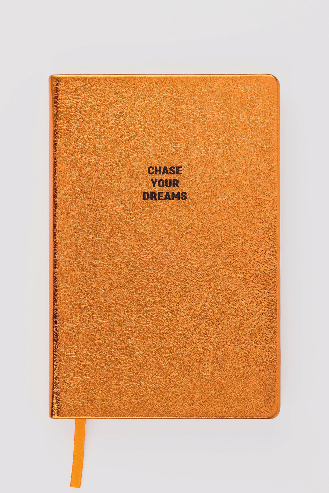 Closed orange metallic A5 notebook with chase your dreams text and orange ribbon marker
