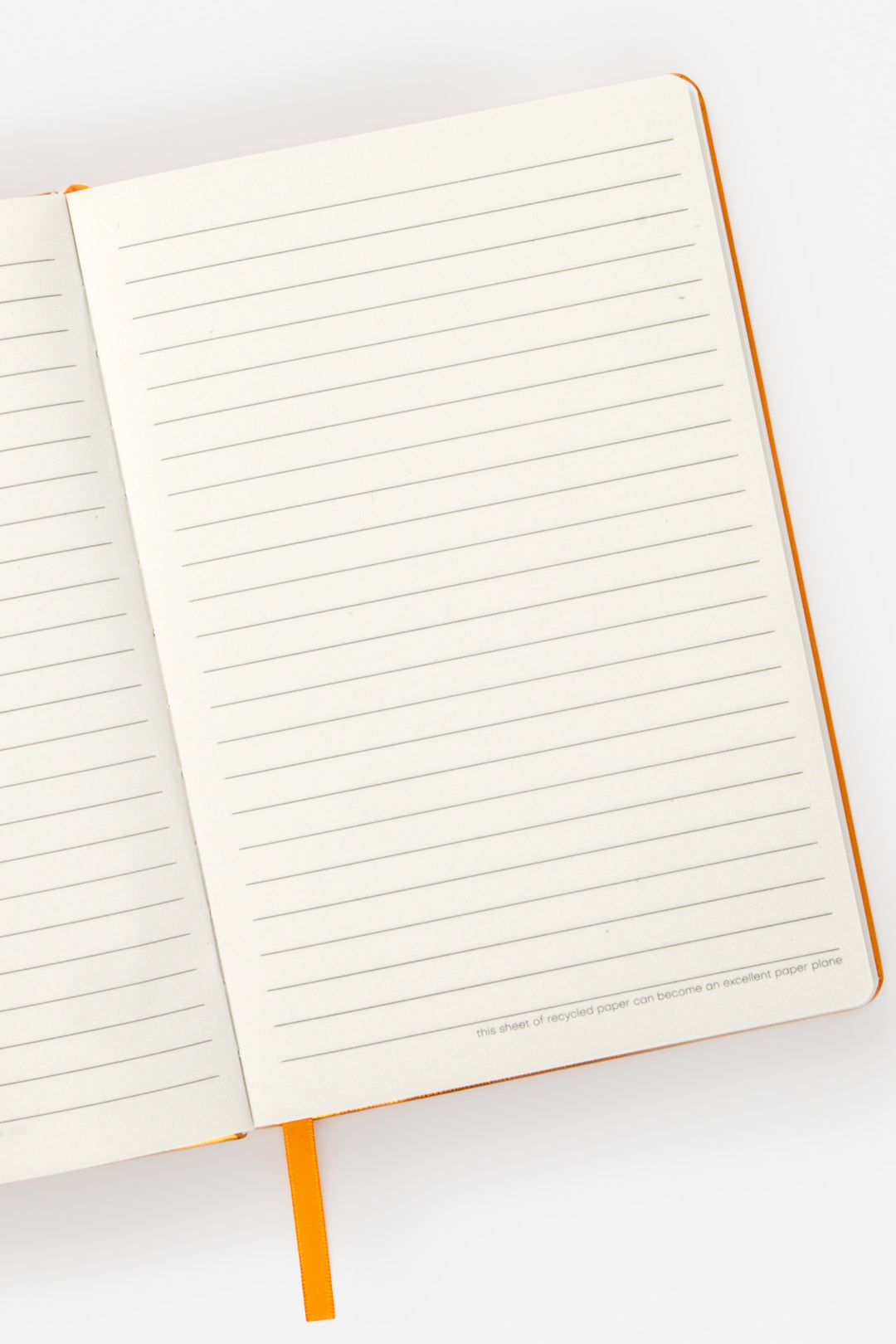 Open A5 notebook showing ruled pages with orange ribbon marker