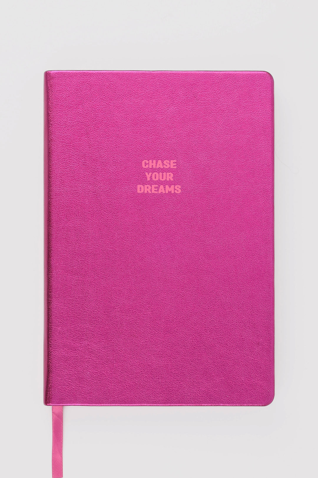 Closed pink metallic A5 notebook with chase your dreams text
