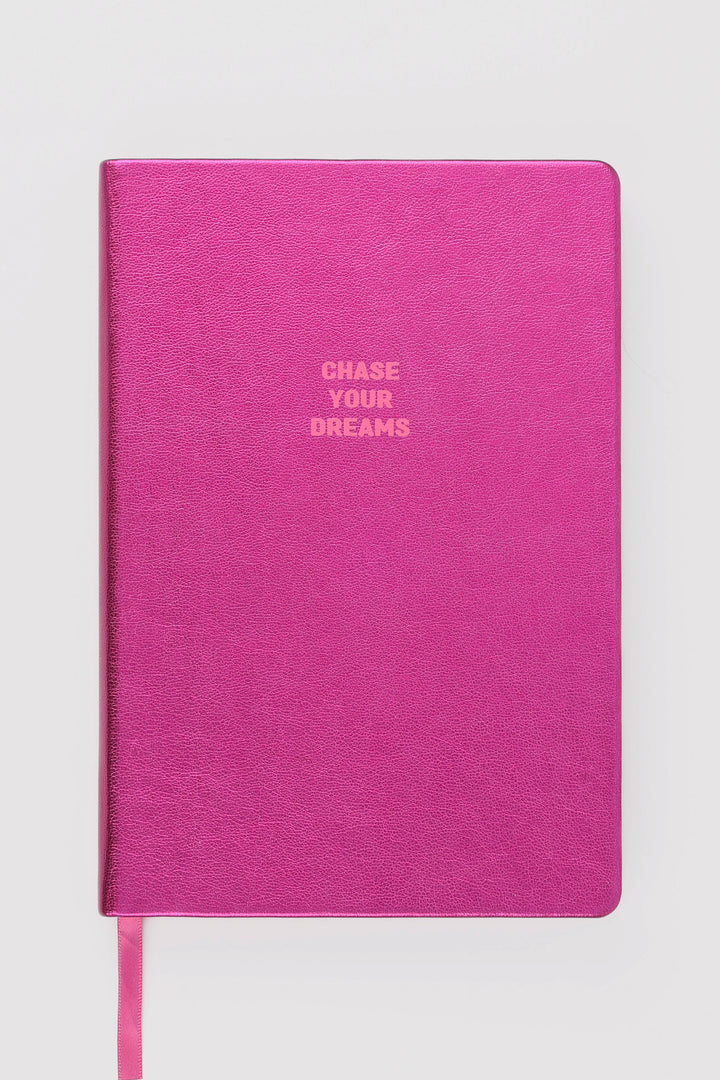 Closed pink metallic A5 notebook with chase your dreams text
