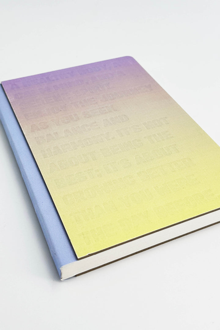 Gradient notebook with purple to yellow color on a white background
