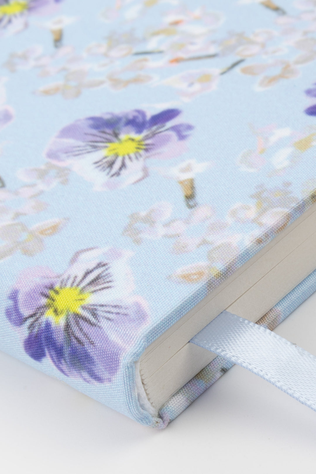 Floral-patterned notebook with a ribbon on a light background