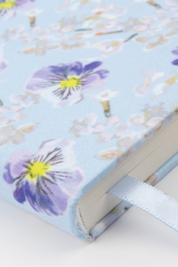Floral-patterned notebook with a ribbon on a light background