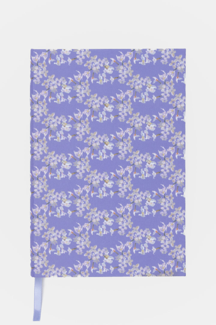 Floral-patterned notebook on a light purple background