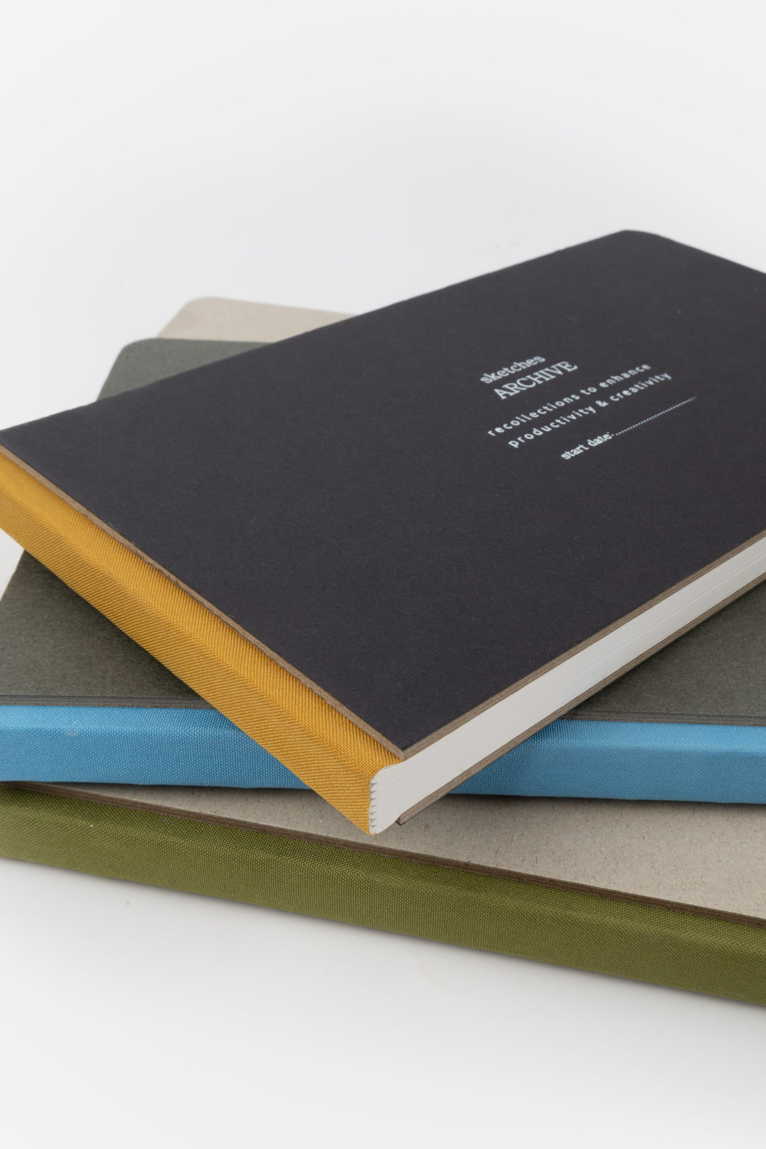 Stack of sketchbooks with different coloured covers 