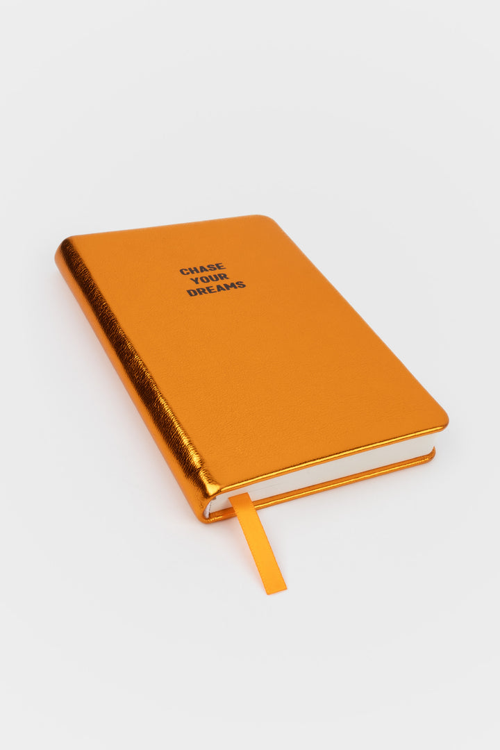 A6 metallic orange notebook angled with the ribbon marker visible
