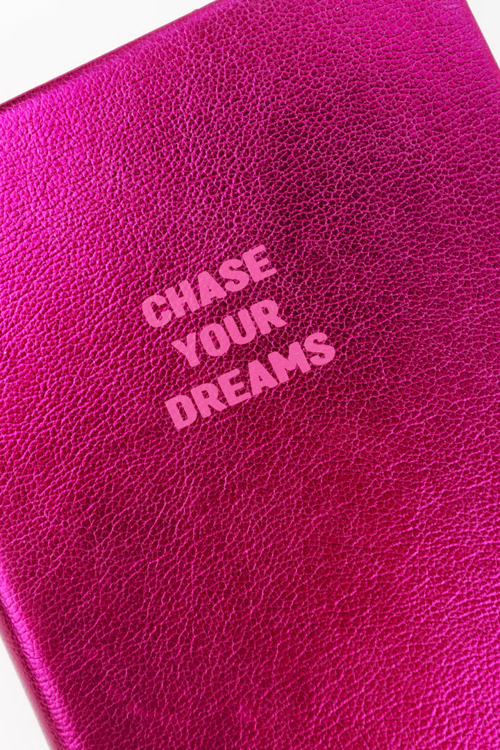 Close-up of pink metallic A6 notebook cover texture with chase your dreams text

