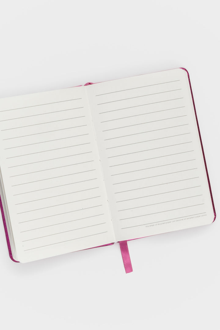 Open A6 notebook showing ruled pages with pink ribbon marker