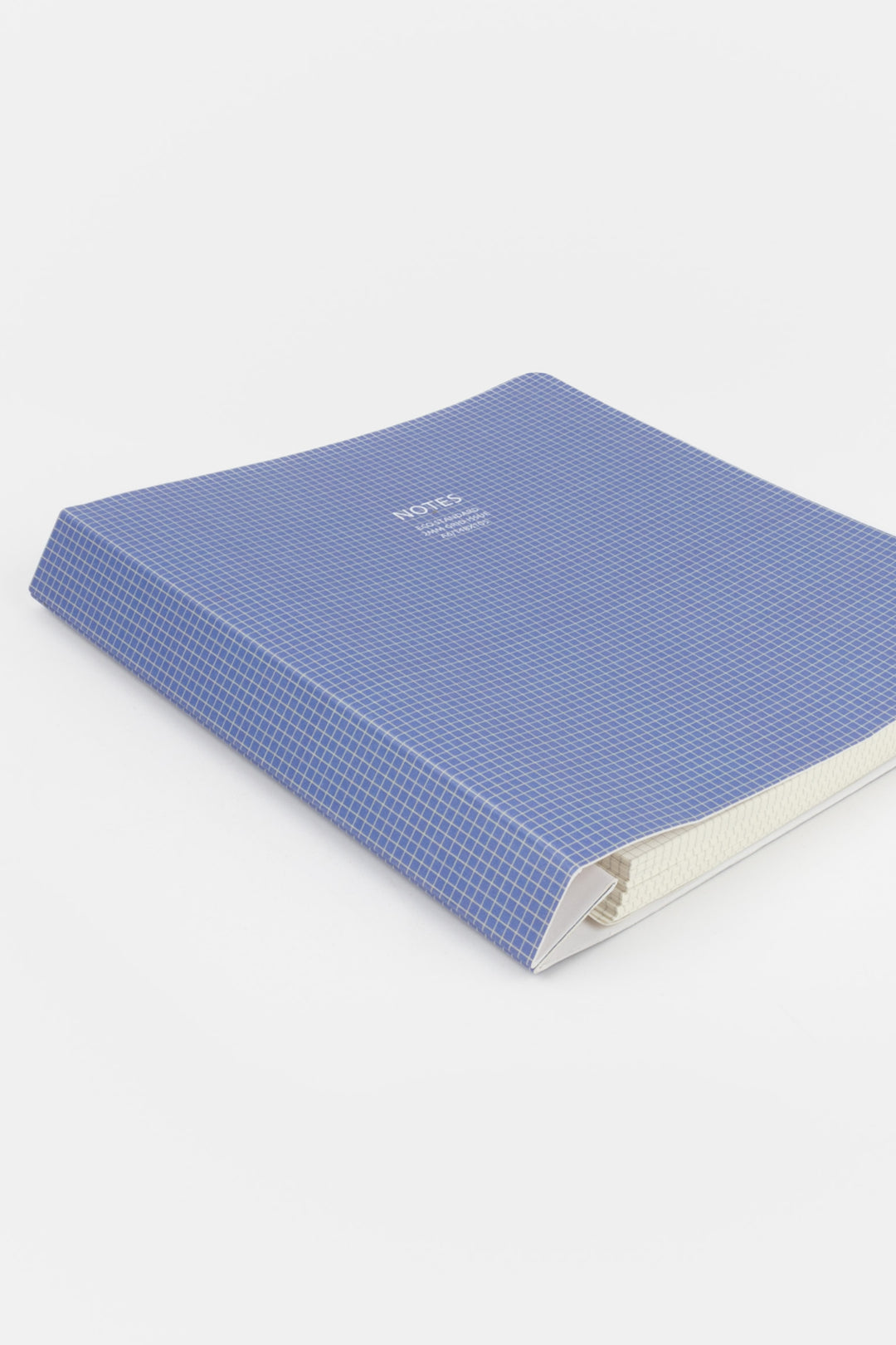 Blue textured notebook with a white brand label on a light gray background