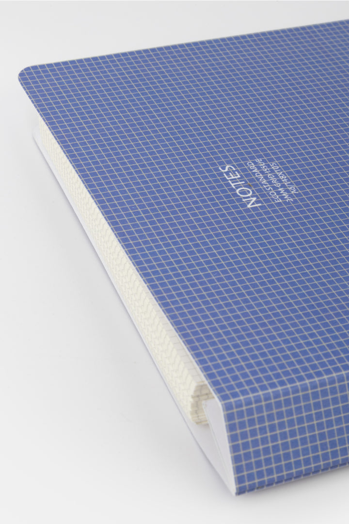 Blue notebook with grid pattern on a white background