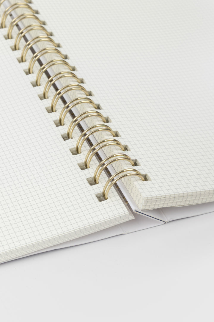 Close-up of a notebook with a wire binding on a white background
