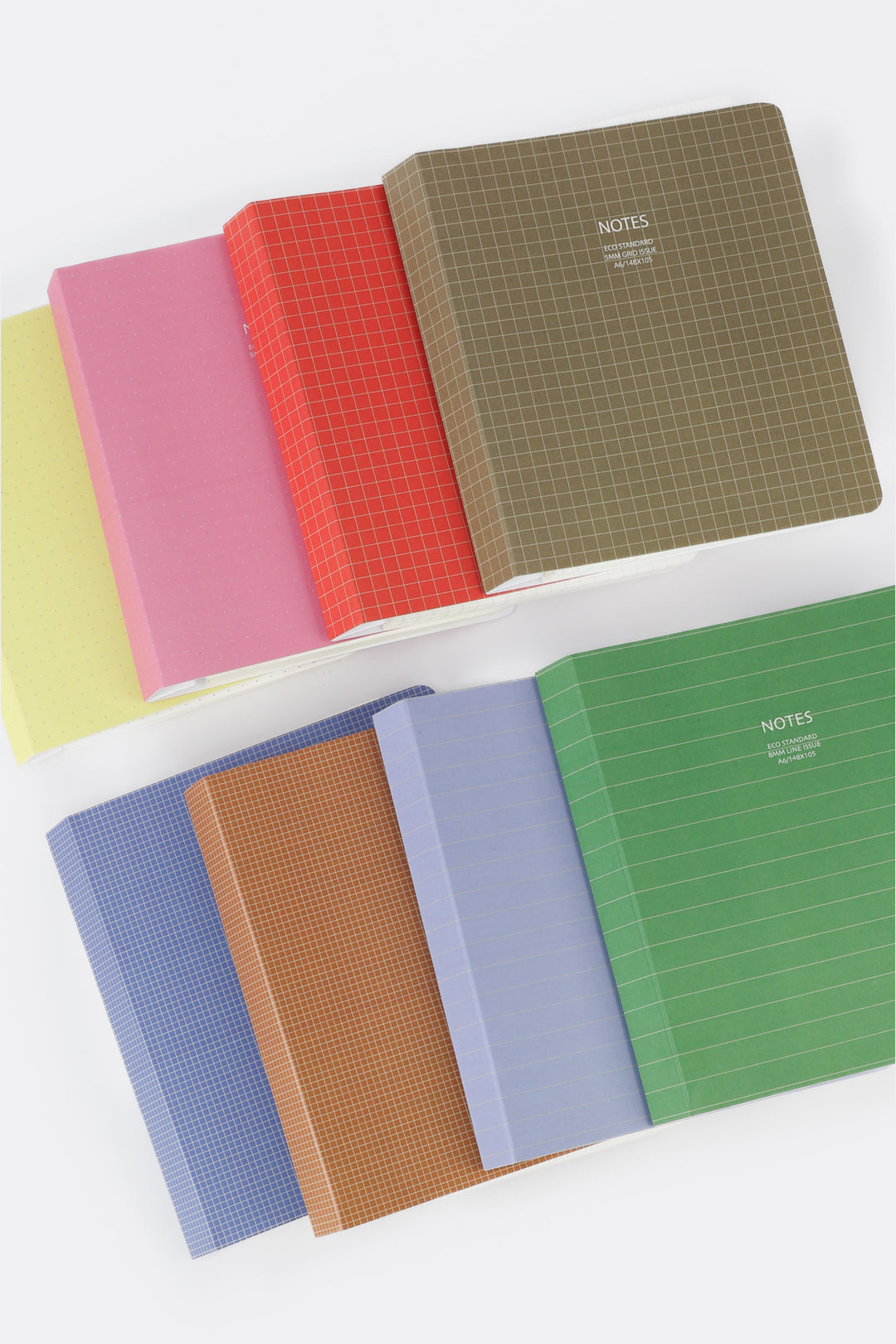 Set of colorful notebooks with grid and plain designs on a white background