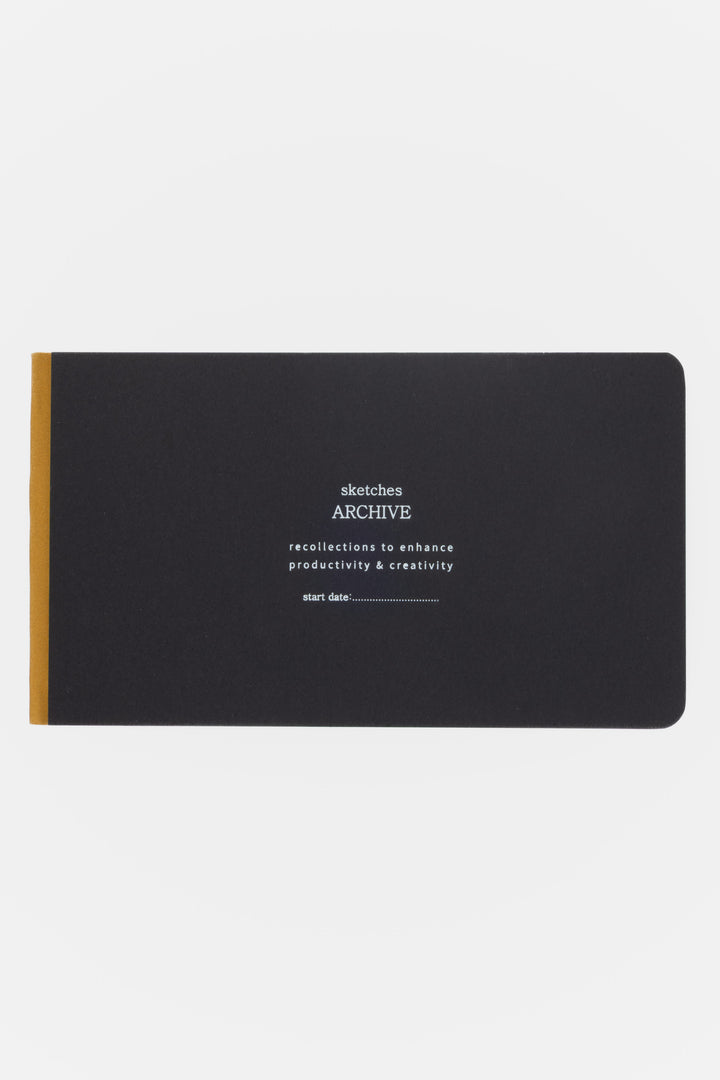 Black sketchbook with white text and gold spine