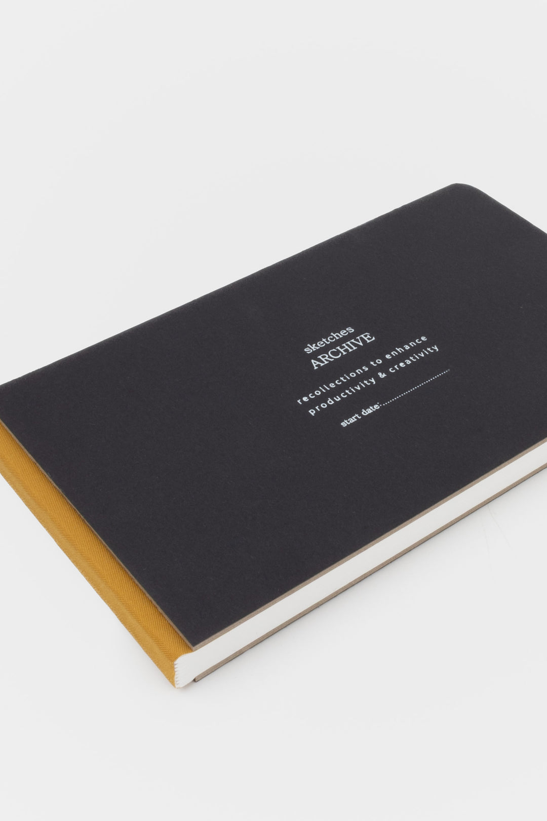 Black sketchbook with white text and gold spine