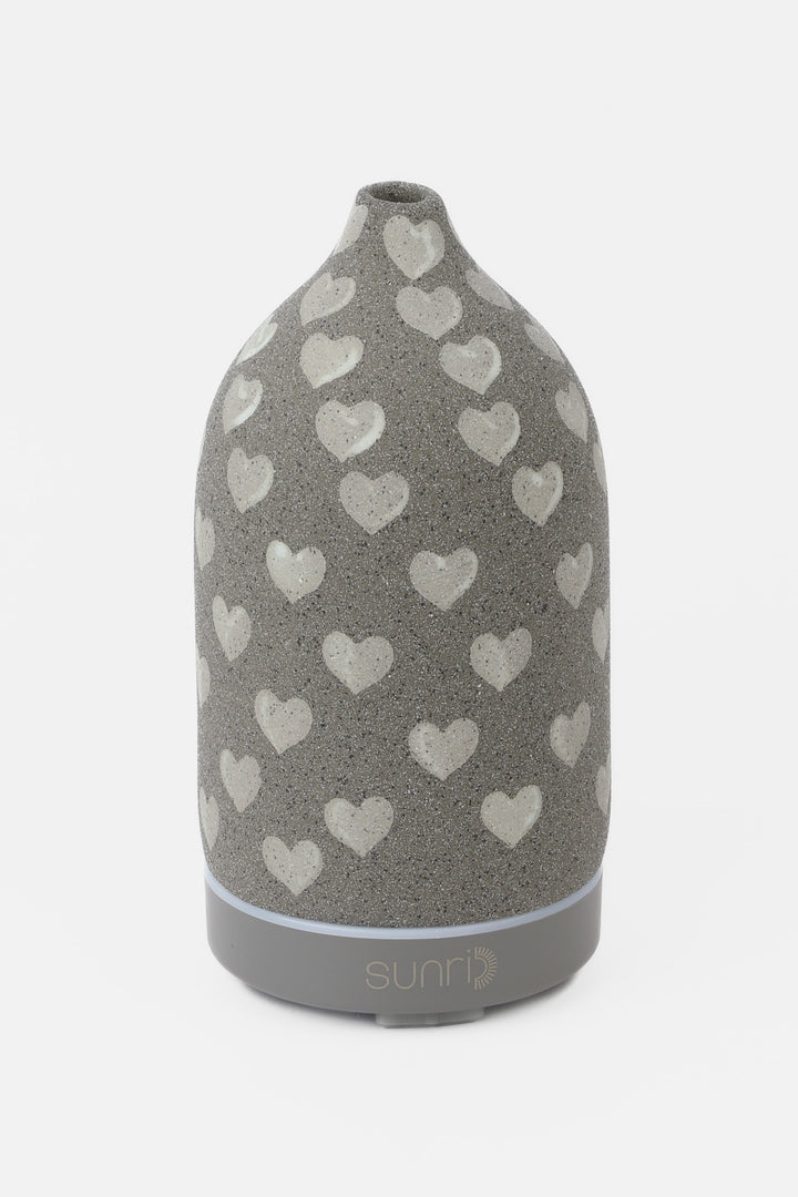 Grey diffuser with heart pattern on a white background