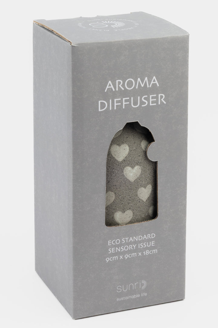 Aroma diffuser packaging with heart designs on a gray background