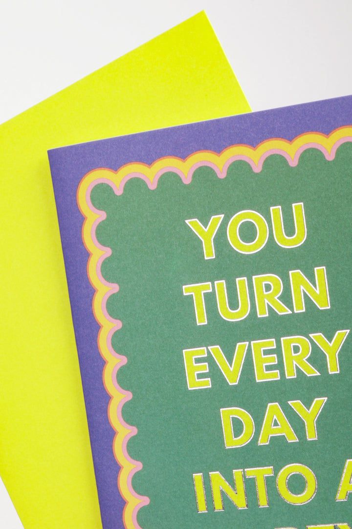 Card with text 'You turn every day into a' on green paper with purple border and yellow text.