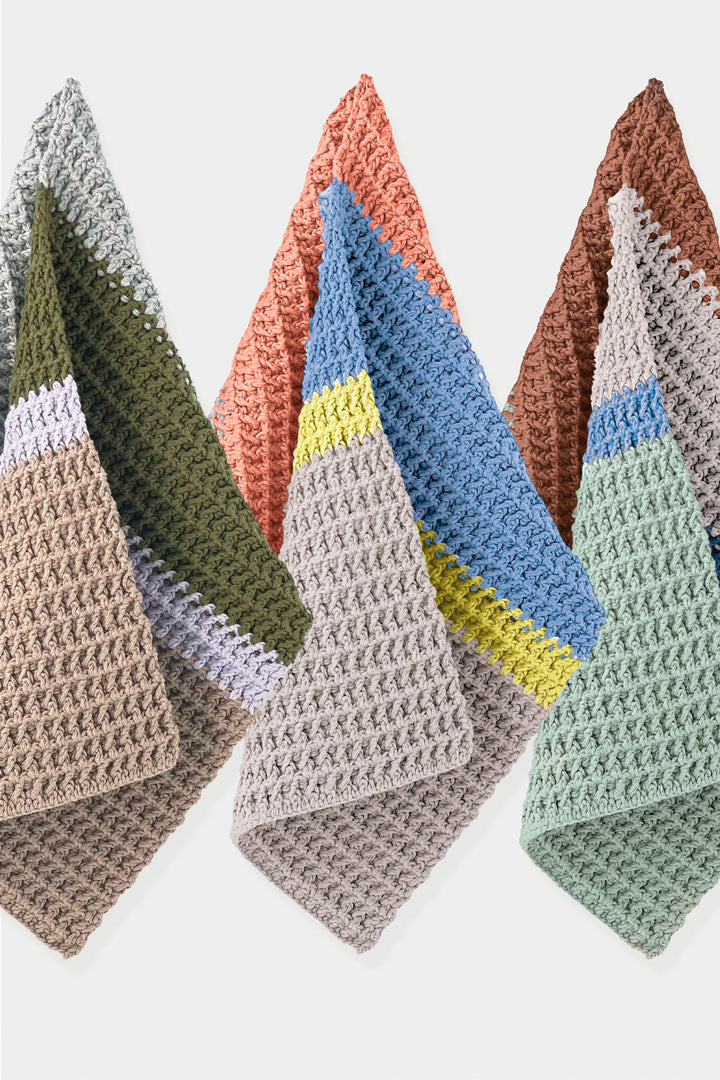 Set of colorful crocheted guest towels on a white background
