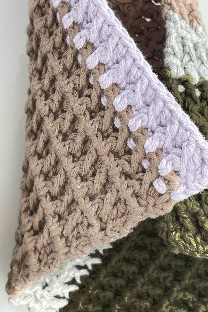 Close-up of a crocheted towel with various color patterns.