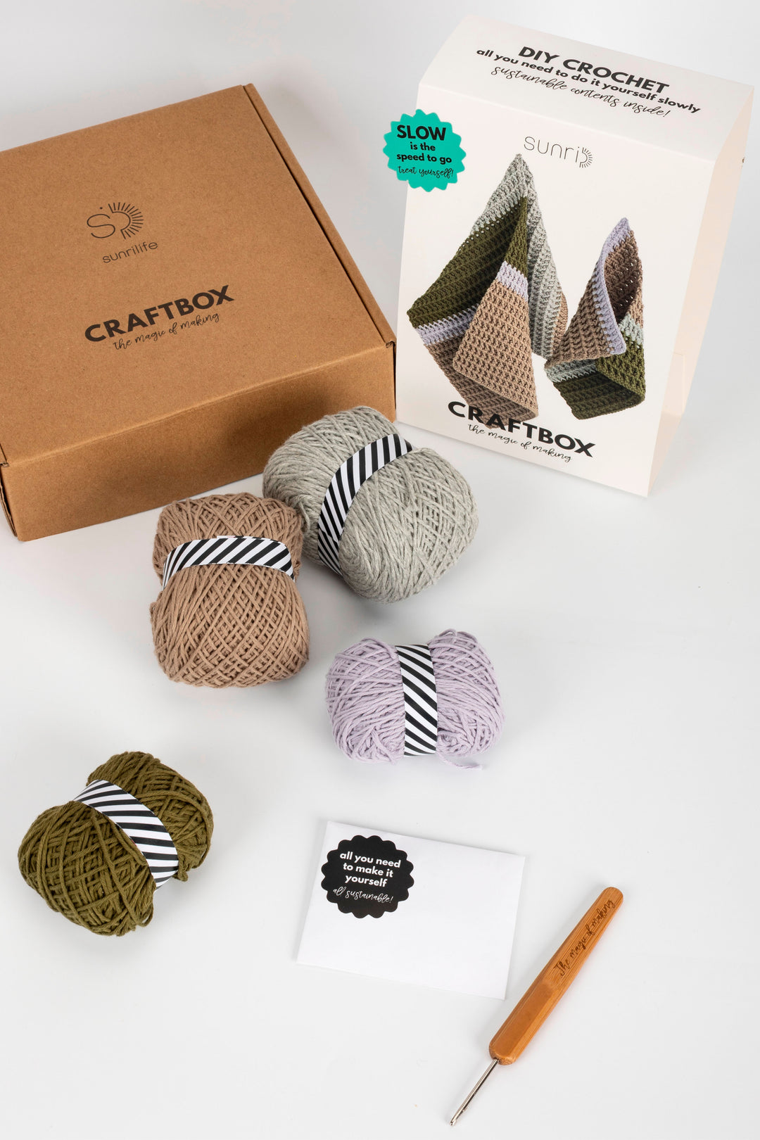 Craftbox with yarn balls and crochet hook on a white background