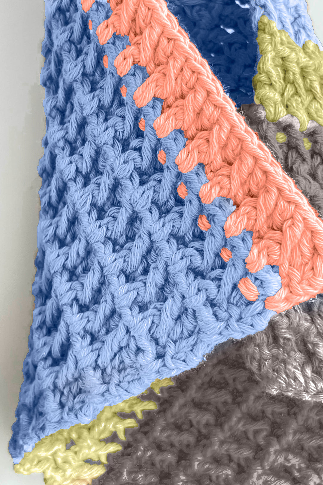 Close-up of a colorful crocheted towel with blue, pink, and gray patterns.