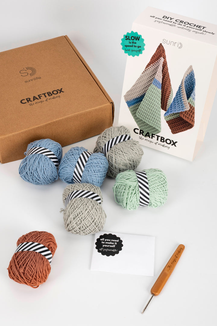CraftBox with yarn balls and a crochet hook on a white background