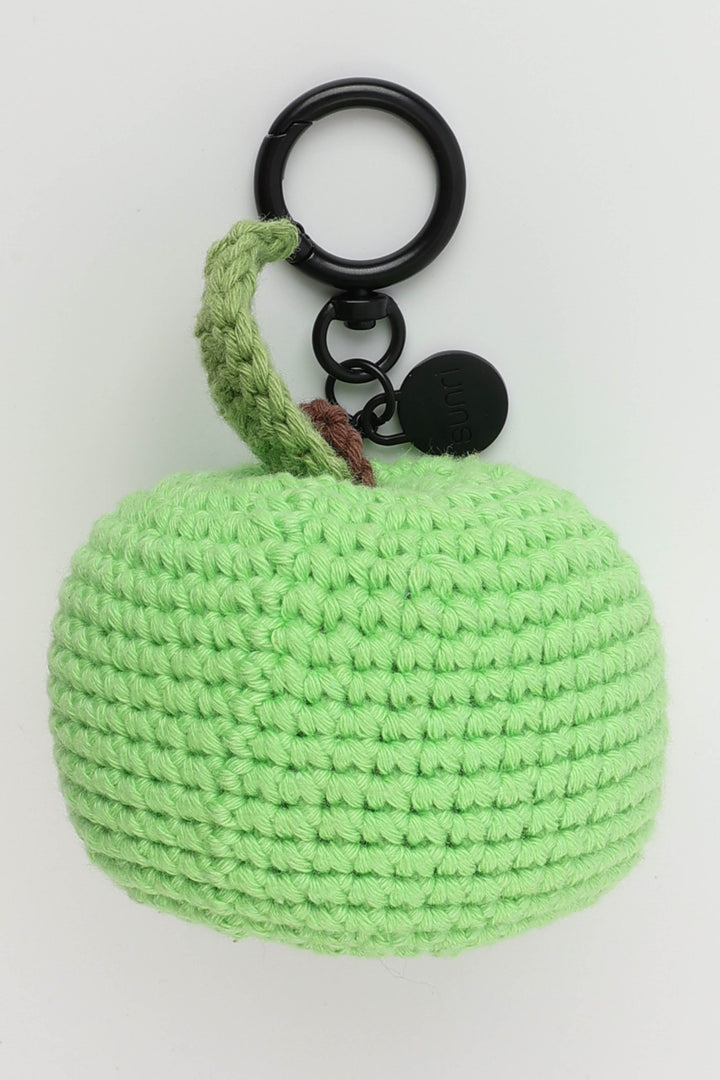 Green crocheted apple keychain on a white background