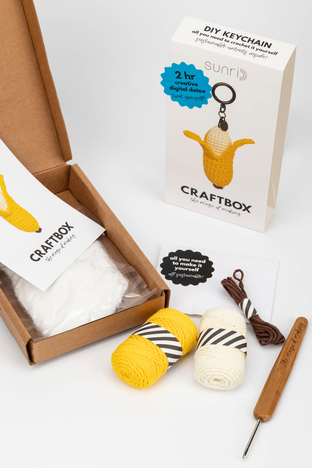 Craft kit with yarn, crochet hook, and keychain packaging on a white background
