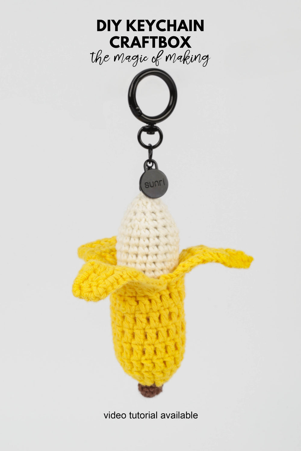 Crocheted banana keychain with a black ring on a white background, featuring 'DIY Keychain Craftbox' text.