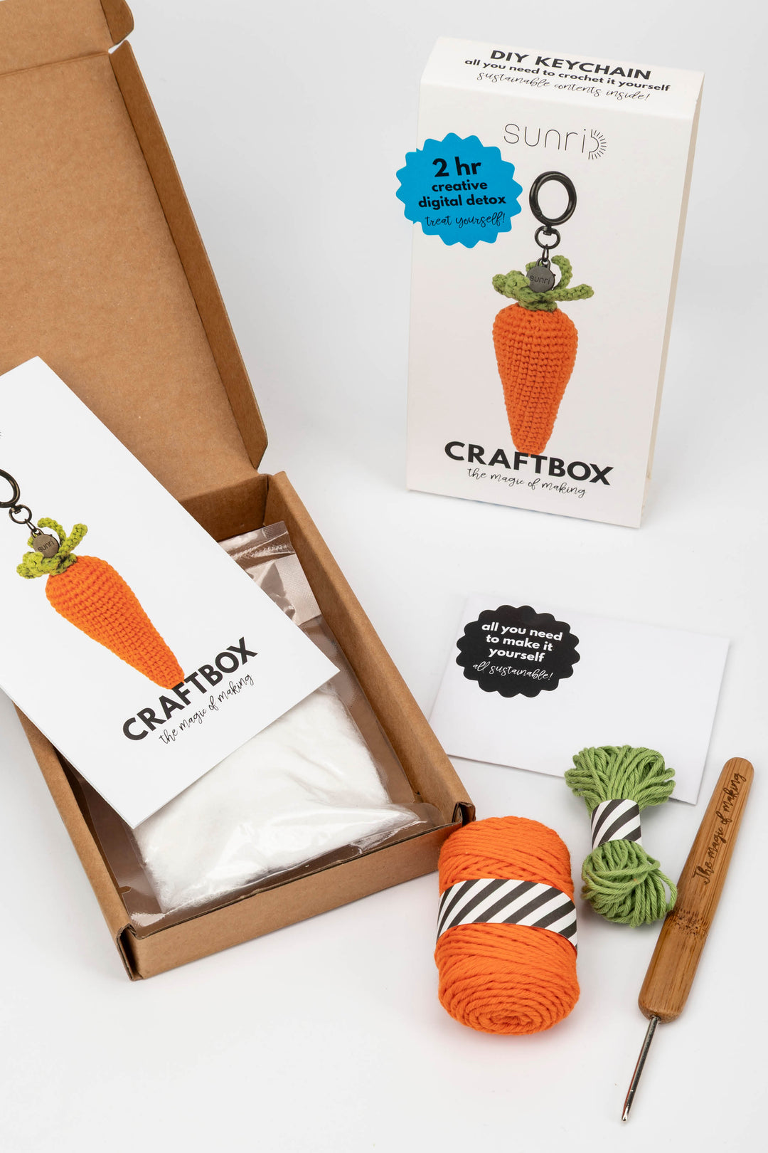 Craft box with yarn, keychain, and tools on a white background