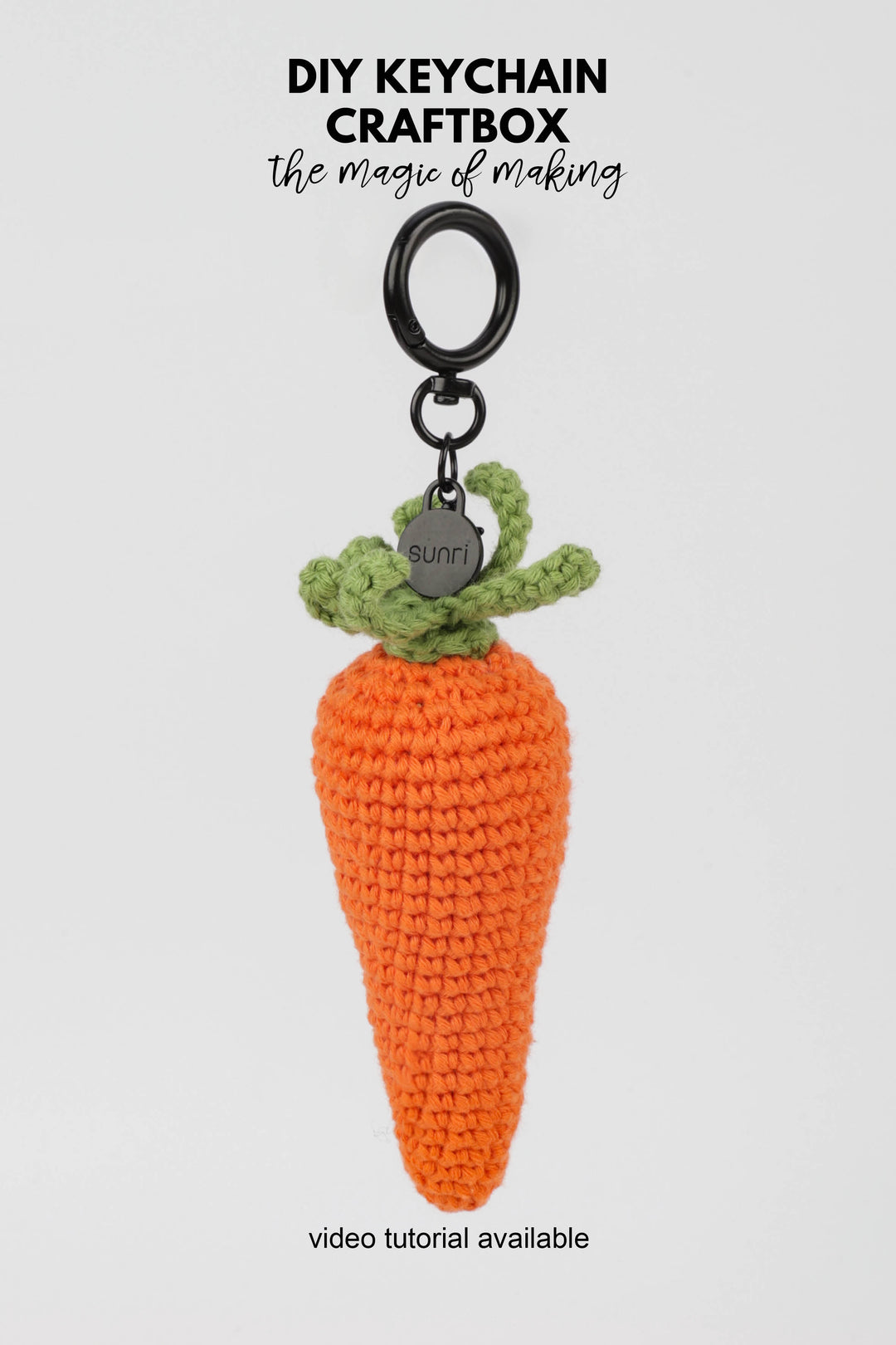 Crocheted carrot keychain with green top on a white background, featuring 'DIY Keychain Craftbox' text.